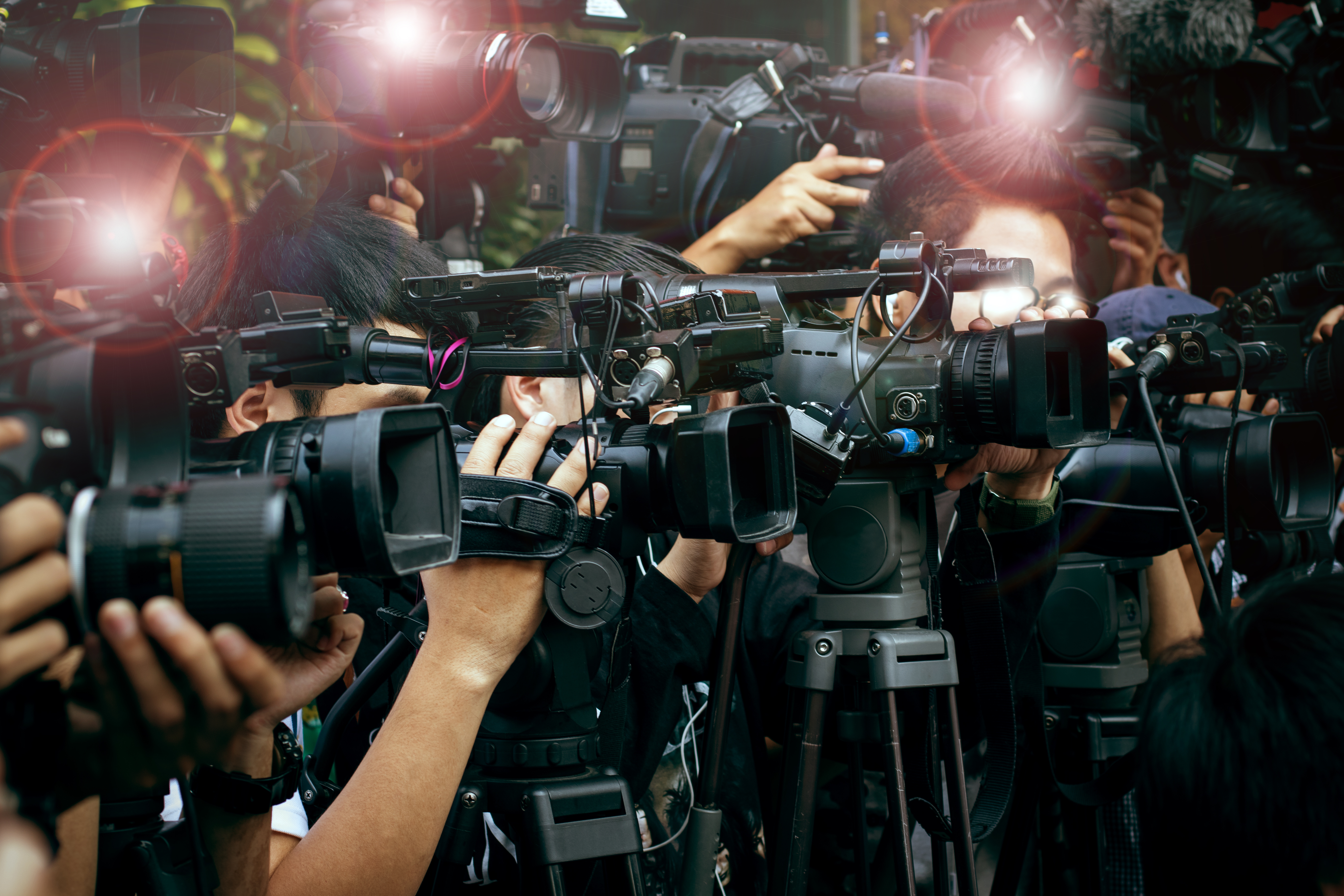 News photojournalists during a press conference following breaking news involving a public relations client